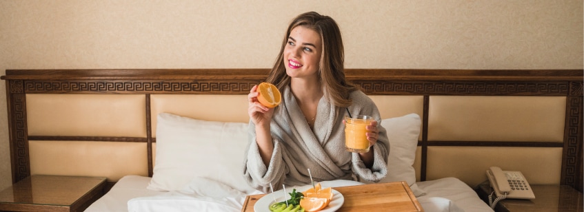 Mujer comiendo comida salurable en cama