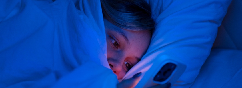 Mujer usando celular en la cama