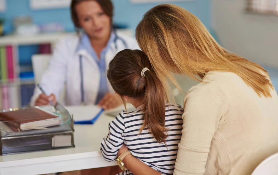 Niña y madre con doctora